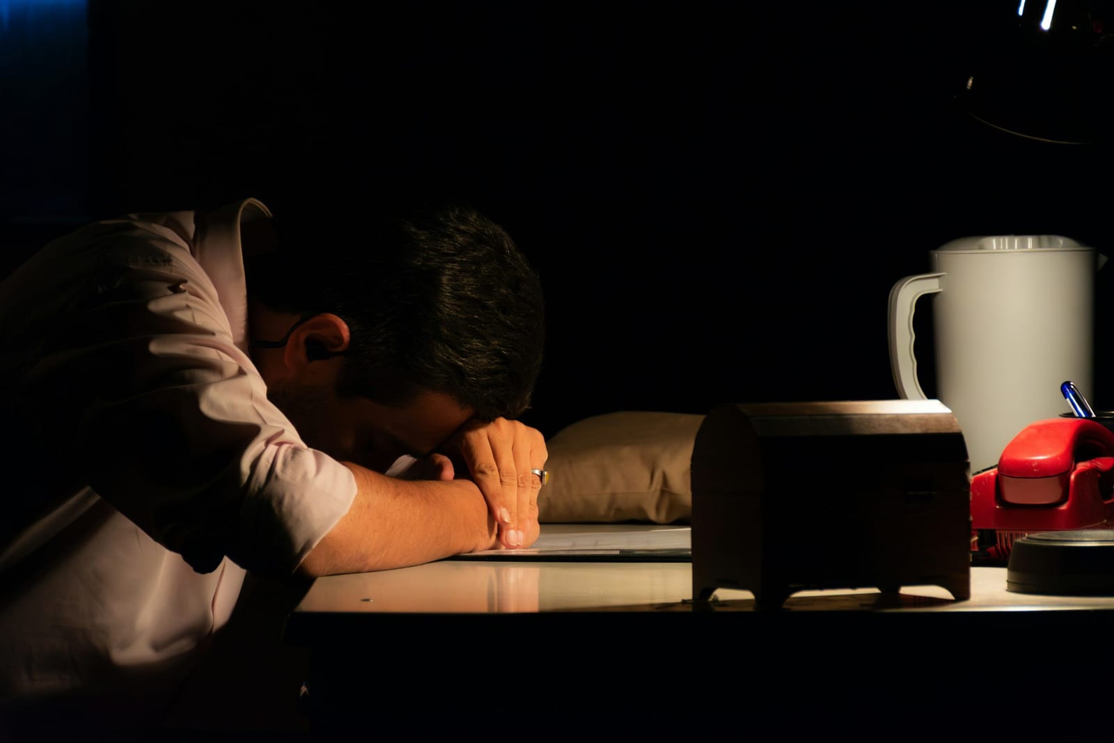 Man sitting alone at a desk during an emotional crisis