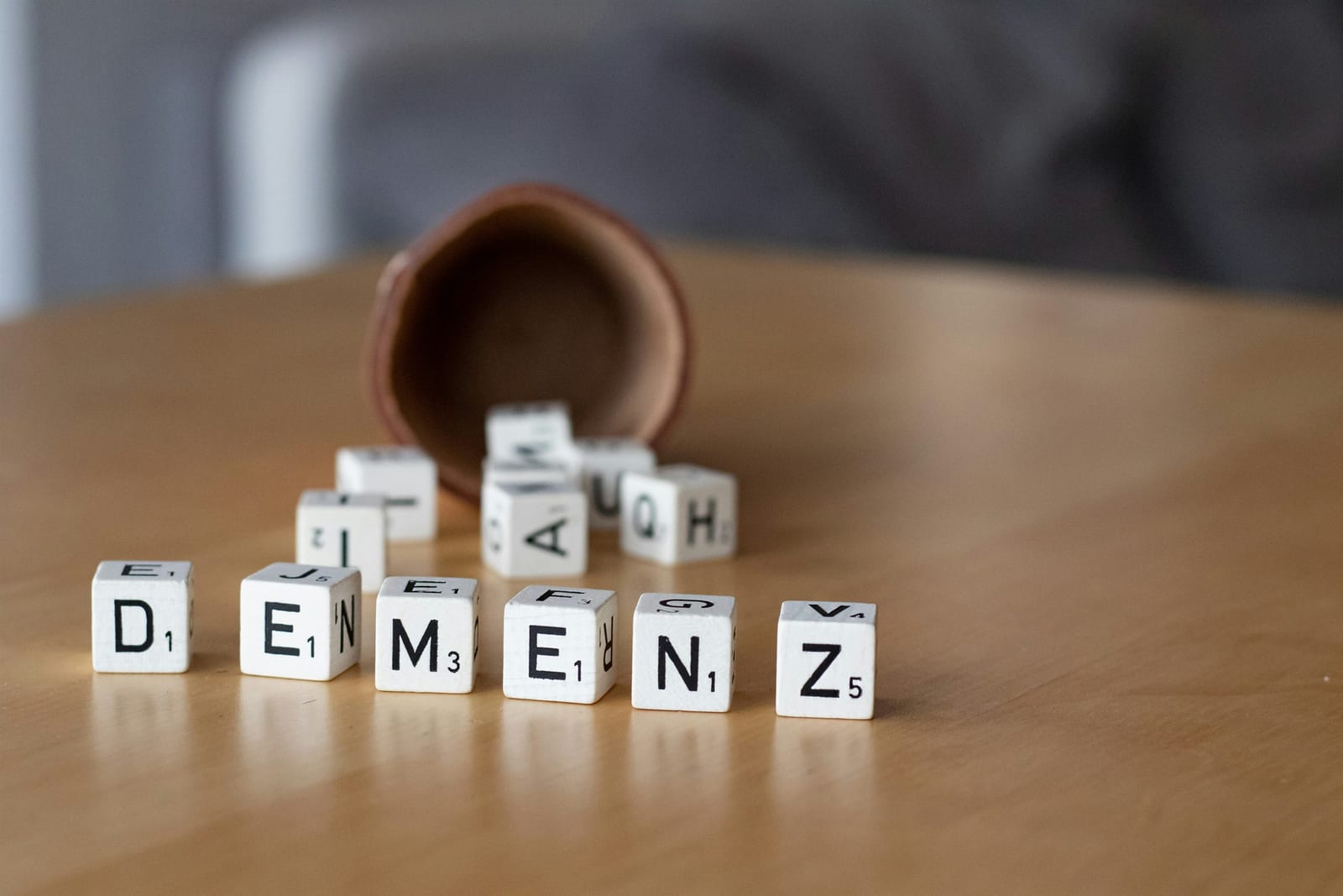 Letter blocks representing dementia beside an overturned cup