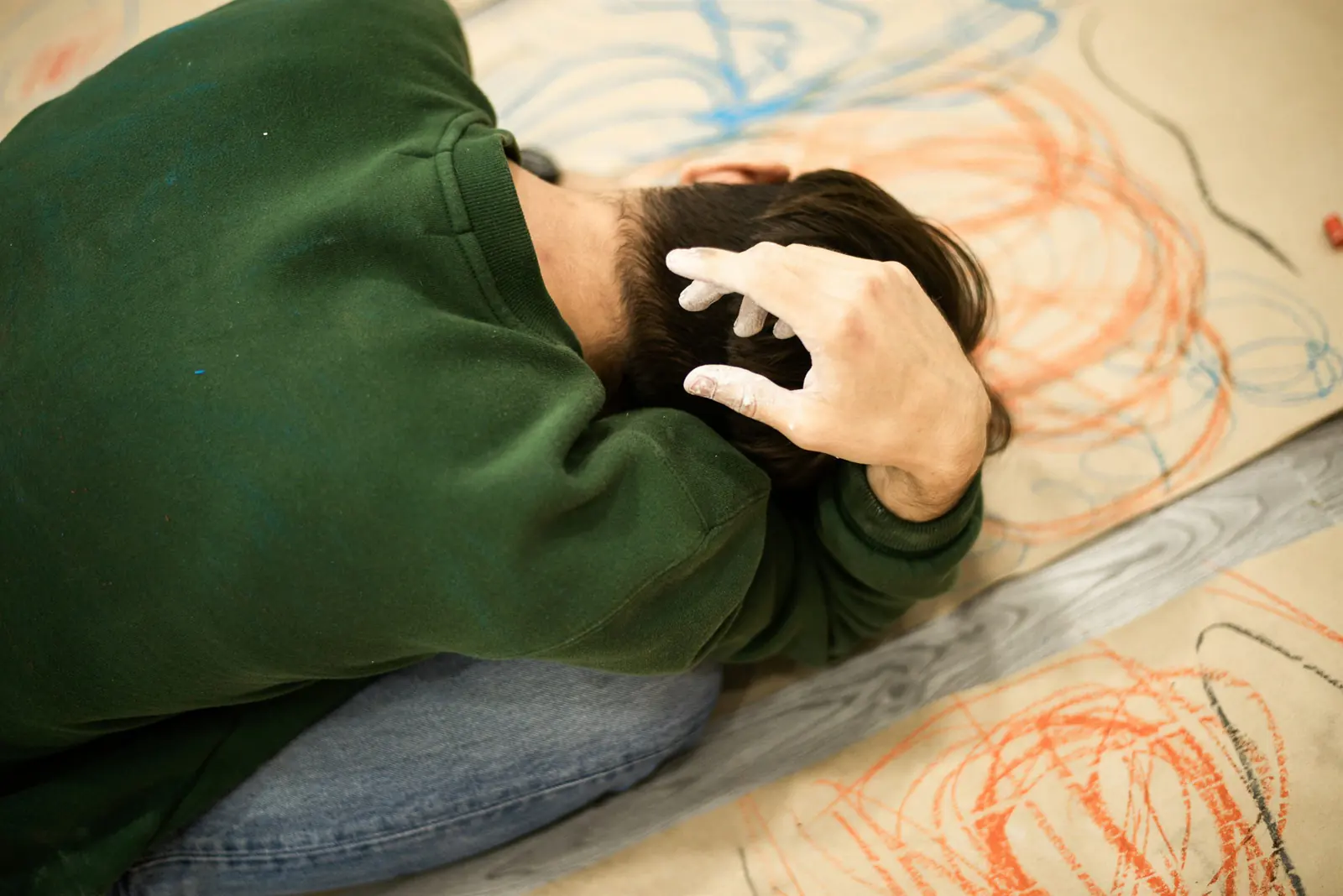 Distressed person lying down with their hand against their head