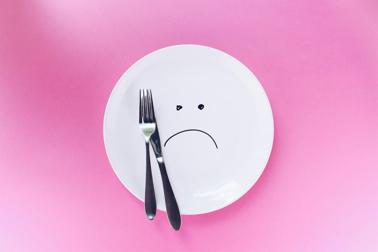 Empty plate with a sad face representing an eating disorder