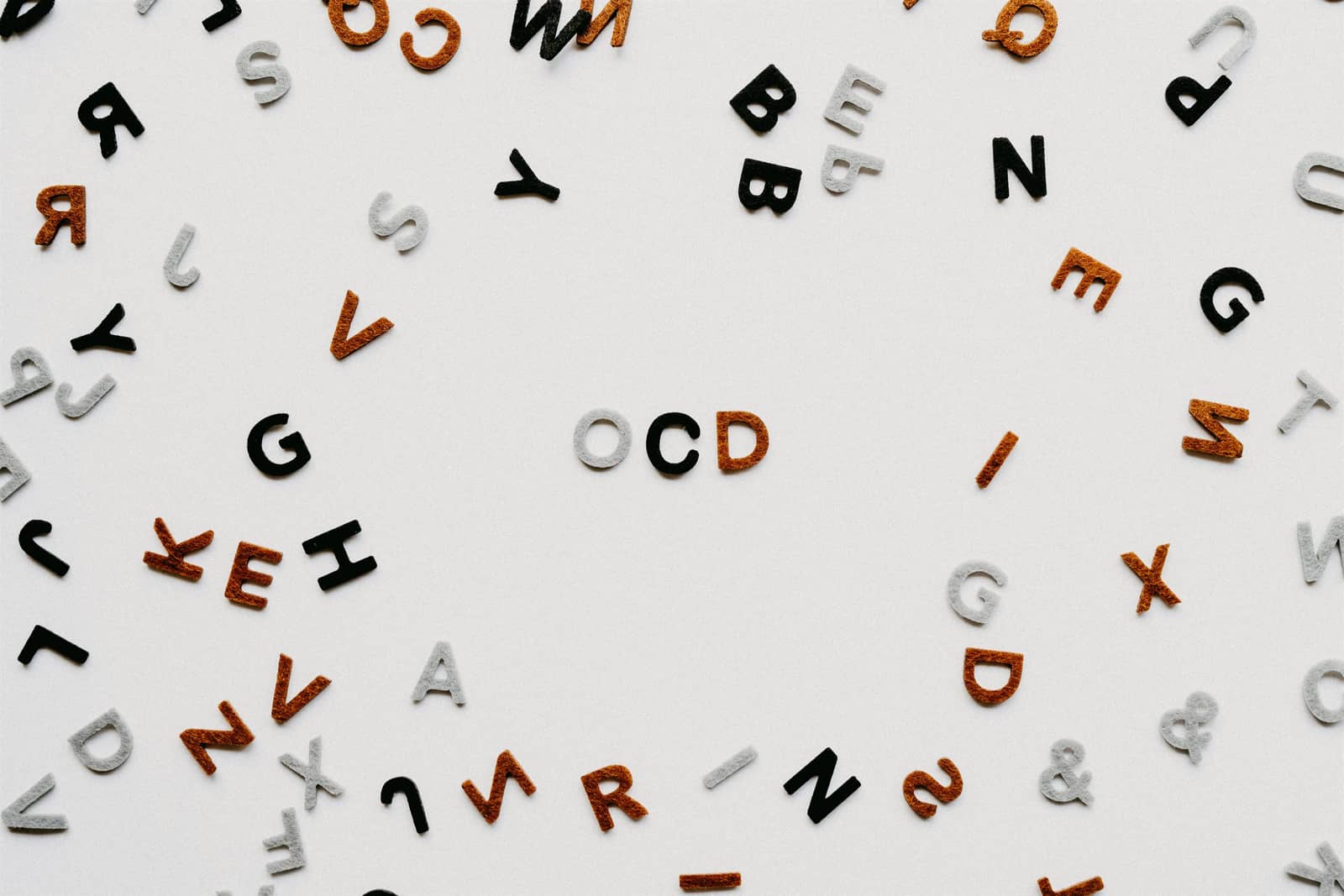 Scattered letter pieces surrounding the letters OCD