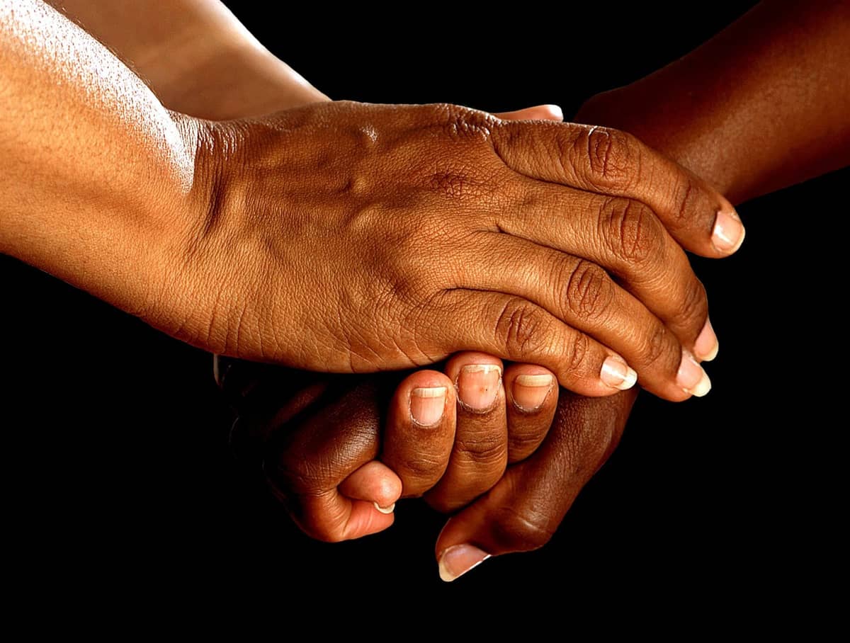 Hands offering compassionate support to another person