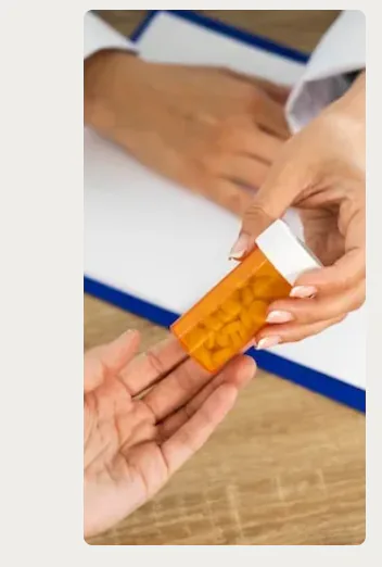 Clinician handing a prescription bottle to a patient